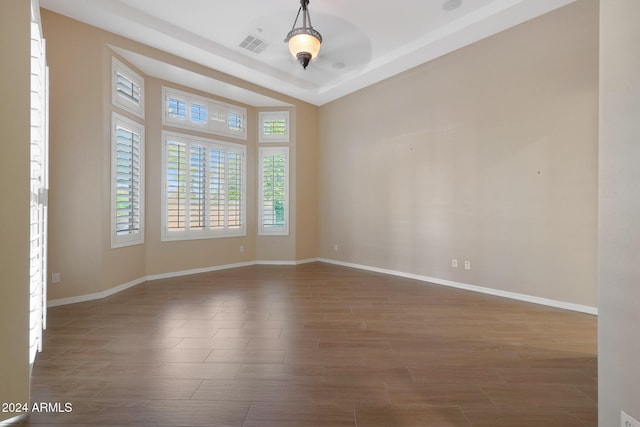 empty room featuring visible vents, baseboards, and wood finished floors