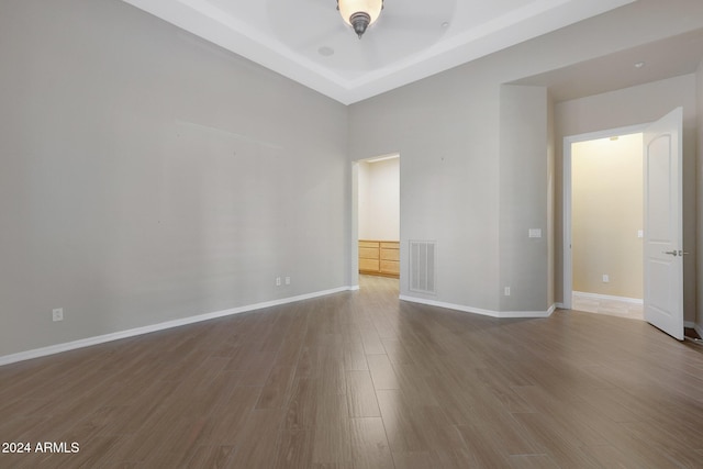 spare room featuring visible vents, baseboards, and wood finished floors