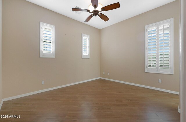 empty room featuring wood finished floors and baseboards