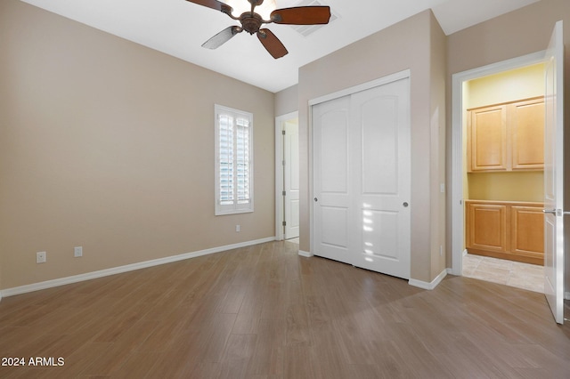 unfurnished bedroom featuring a ceiling fan, a closet, baseboards, and light wood finished floors