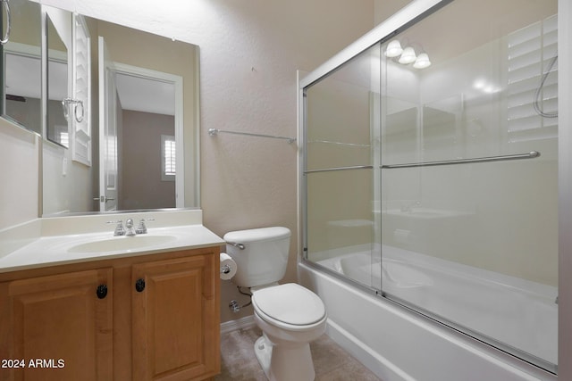 bathroom with tile patterned flooring, enclosed tub / shower combo, vanity, and toilet