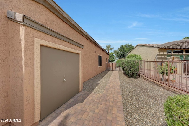 view of side of home with fence and stucco siding