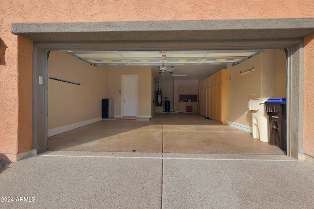 garage featuring a garage door opener and strapped water heater