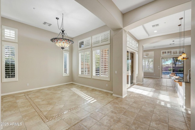 empty room with a wealth of natural light, visible vents, and baseboards