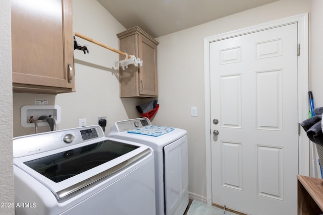 laundry area with washing machine and clothes dryer and cabinets