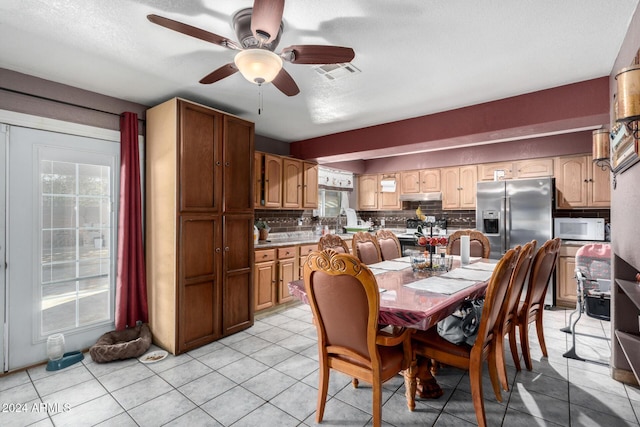 dining space featuring ceiling fan, light tile patterned floors, and a textured ceiling