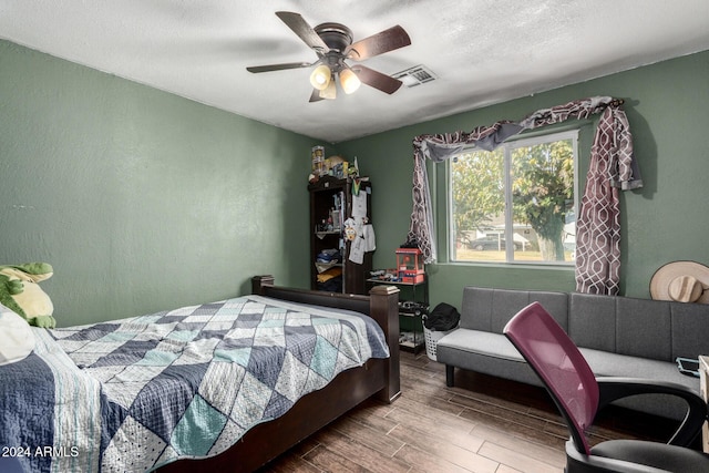 bedroom featuring ceiling fan, a textured ceiling, and hardwood / wood-style flooring