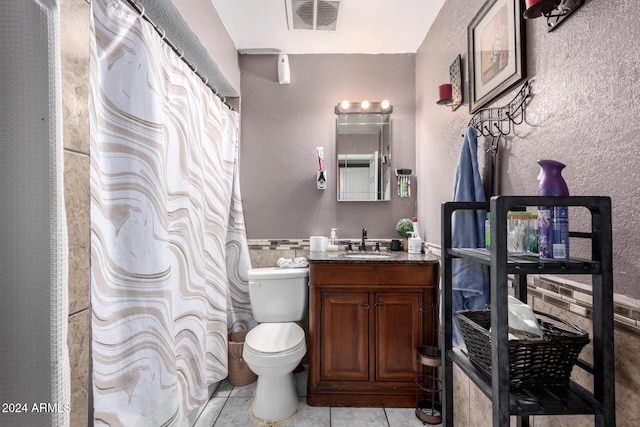 bathroom with tile patterned flooring, vanity, and toilet