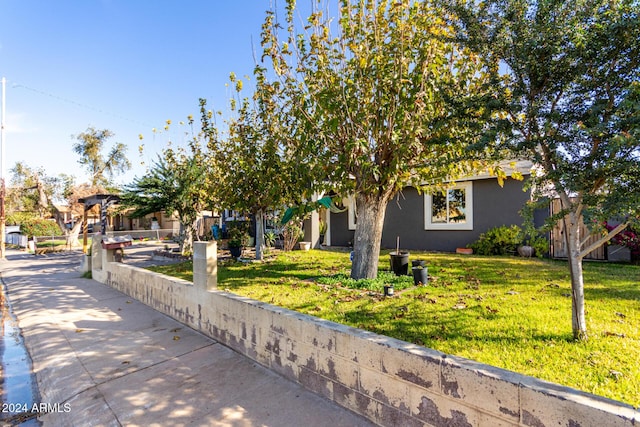 view of property hidden behind natural elements featuring a front yard