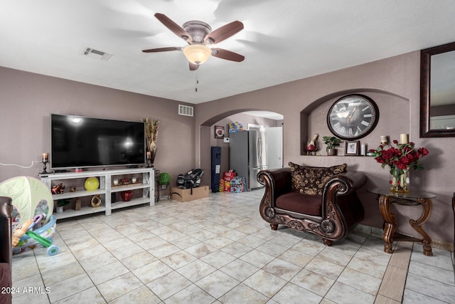 tiled living room with ceiling fan