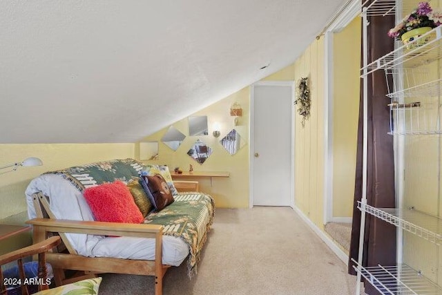 sitting room with carpet floors and vaulted ceiling