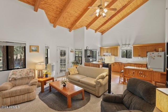 living room with beamed ceiling, high vaulted ceiling, a wealth of natural light, and ceiling fan