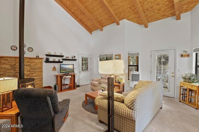 living room with a wood stove, light carpet, and high vaulted ceiling