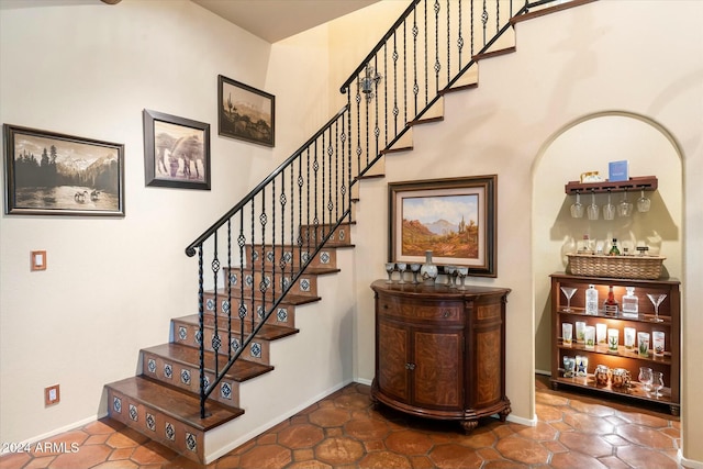 staircase with tile patterned flooring and indoor bar