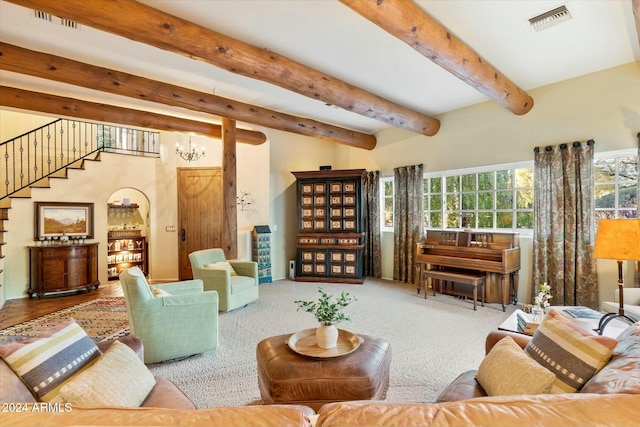 carpeted living room featuring beamed ceiling and a chandelier