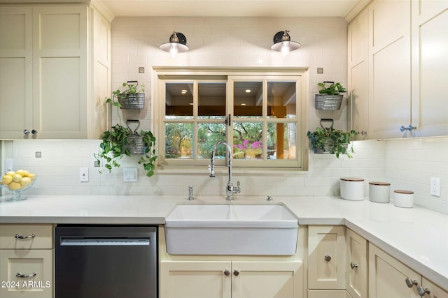 kitchen with tasteful backsplash, sink, stainless steel dishwasher, and cream cabinetry