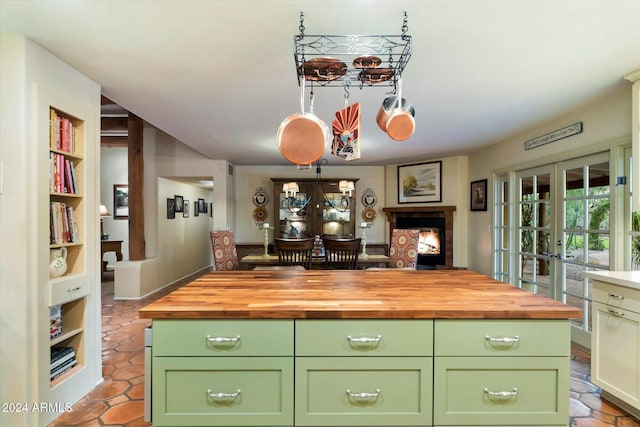 kitchen with wooden counters, french doors, a center island, and green cabinetry