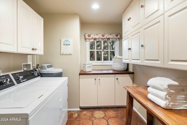 laundry area with washer and dryer, cabinets, and dark tile patterned floors