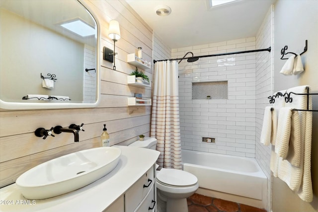 full bathroom featuring vanity, wood walls, shower / bath combo, a skylight, and toilet