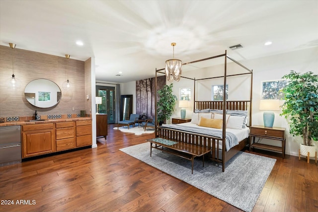 bedroom with a chandelier, dark hardwood / wood-style flooring, and sink