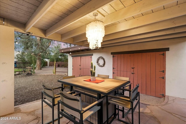 dining area featuring a notable chandelier, beam ceiling, and wood ceiling