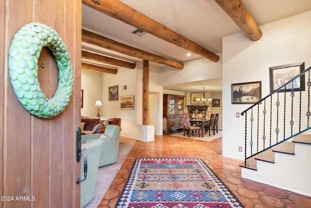 entrance foyer with beamed ceiling, an inviting chandelier, and tile patterned floors