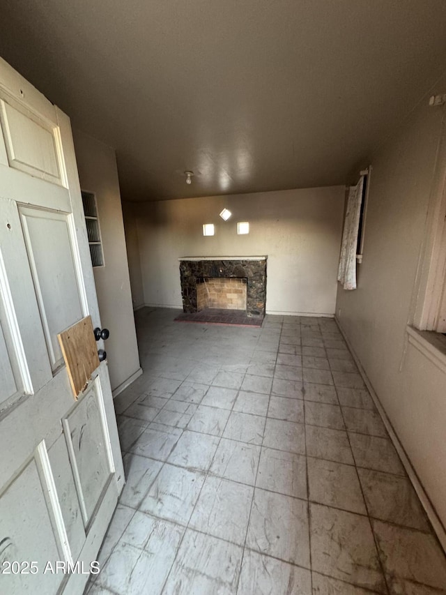 unfurnished living room with a stone fireplace