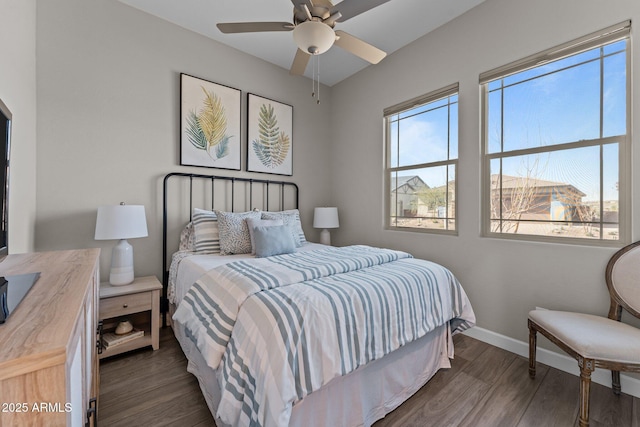 bedroom featuring multiple windows, baseboards, and dark wood-type flooring