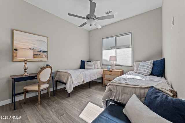 bedroom with a ceiling fan, baseboards, visible vents, and wood finished floors