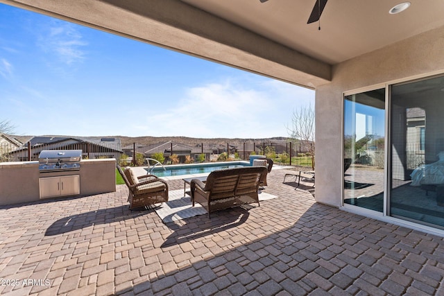 view of patio with area for grilling, a grill, a ceiling fan, fence, and a fenced in pool