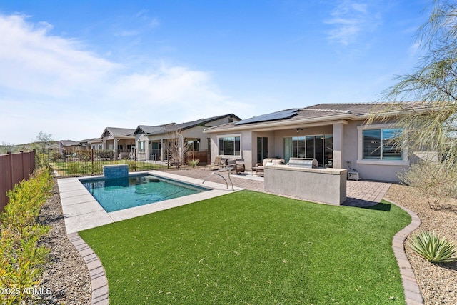 back of property featuring a patio, a fenced backyard, a yard, roof mounted solar panels, and stucco siding