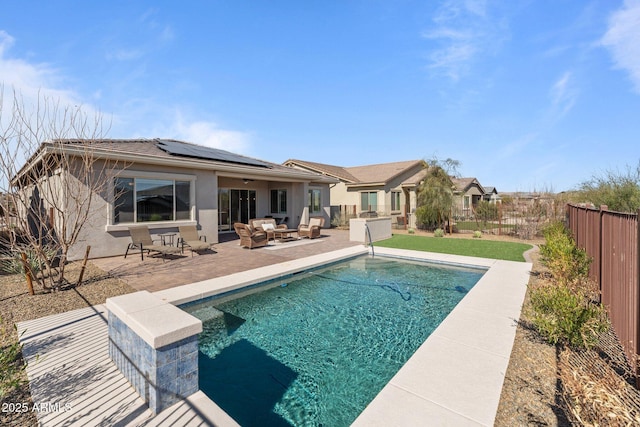 rear view of house with a fenced in pool, a patio, solar panels, a fenced backyard, and stucco siding