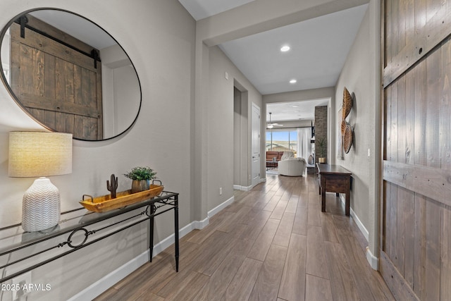 corridor featuring recessed lighting, wood finished floors, and baseboards