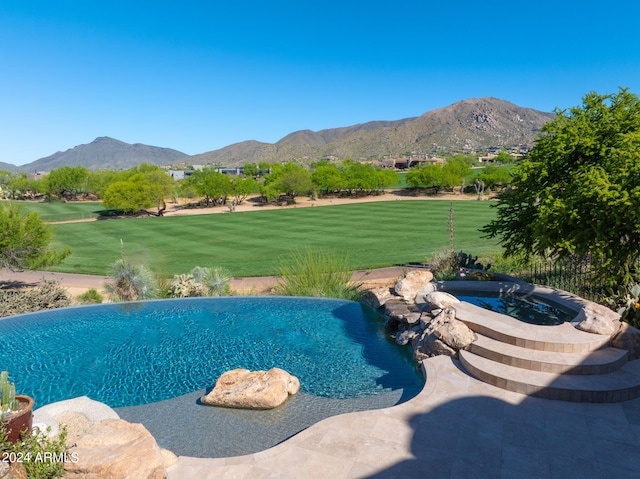 view of pool featuring a mountain view, an in ground hot tub, and a lawn