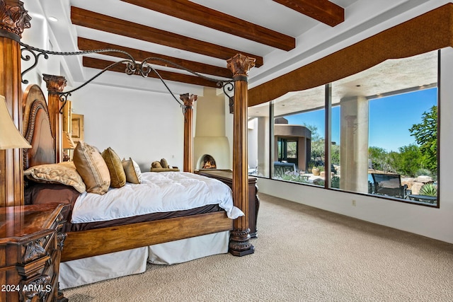 carpeted bedroom with beamed ceiling