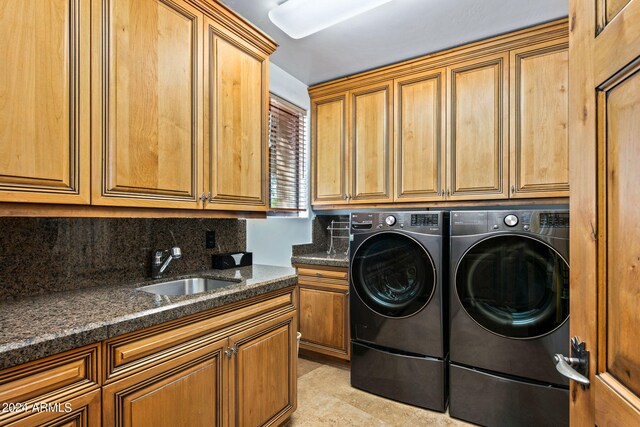 laundry room featuring washer and clothes dryer, cabinets, and sink