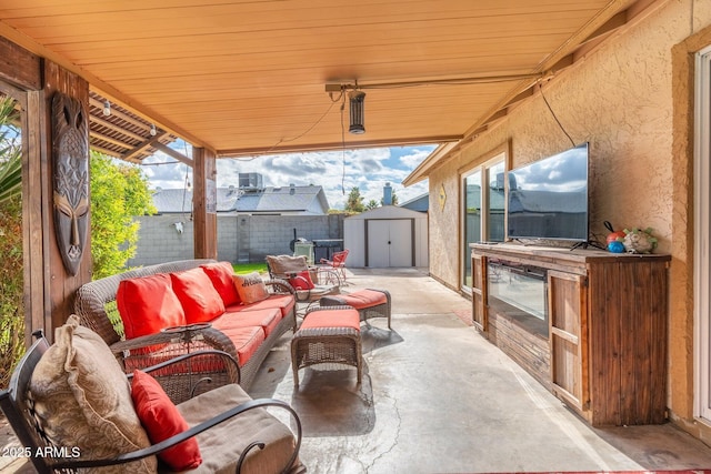 view of patio / terrace featuring an outdoor living space, a fenced backyard, a storage shed, and an outdoor structure