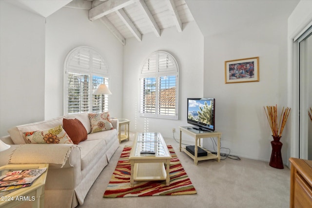 carpeted living room with beam ceiling and high vaulted ceiling