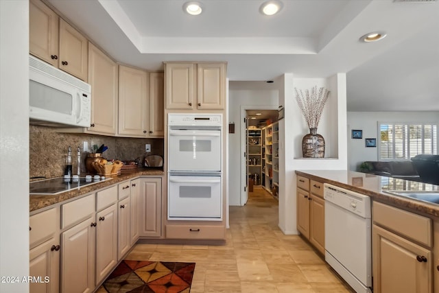 kitchen featuring backsplash, white appliances, a raised ceiling, sink, and light tile patterned floors