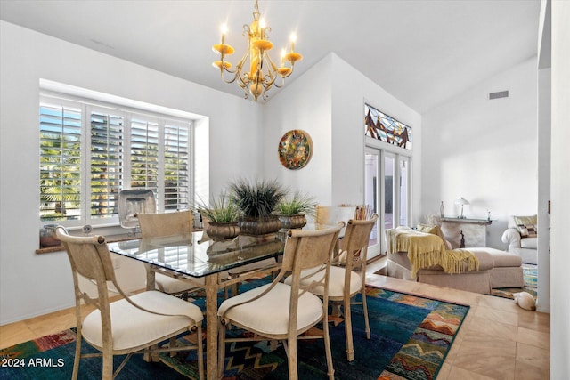 tiled dining room with an inviting chandelier and lofted ceiling