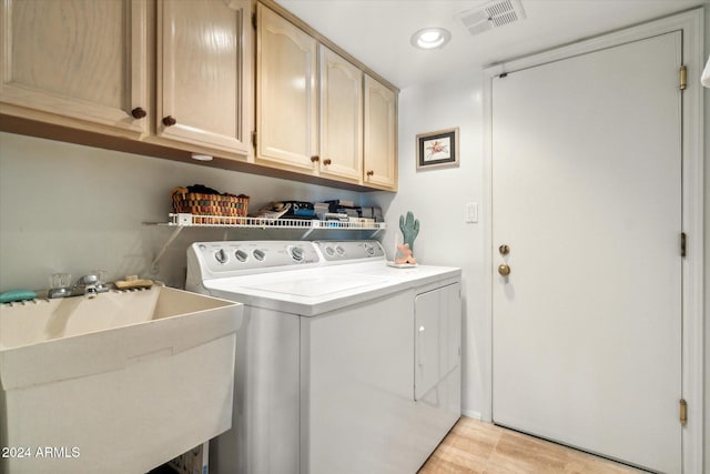 laundry area with cabinets, independent washer and dryer, light hardwood / wood-style floors, and sink