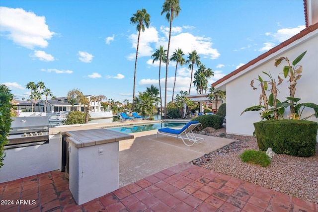 view of swimming pool featuring grilling area and a patio area