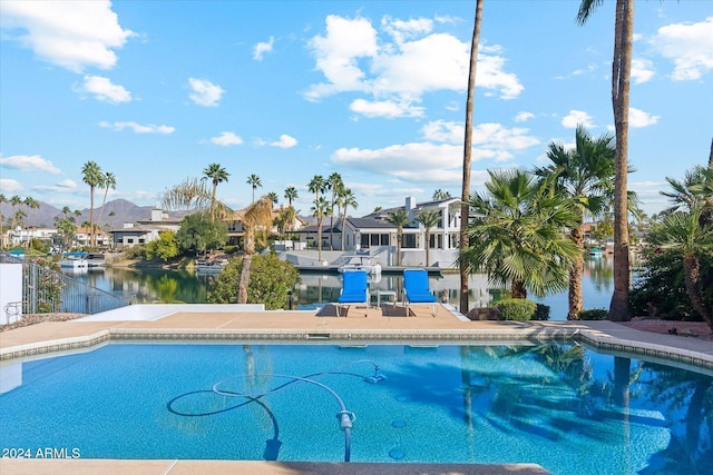 view of swimming pool featuring a water view and a patio