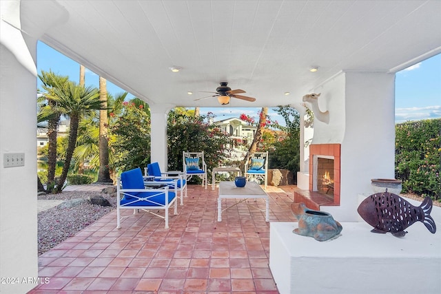 view of patio featuring ceiling fan and exterior fireplace