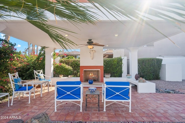 view of patio / terrace featuring exterior fireplace and ceiling fan