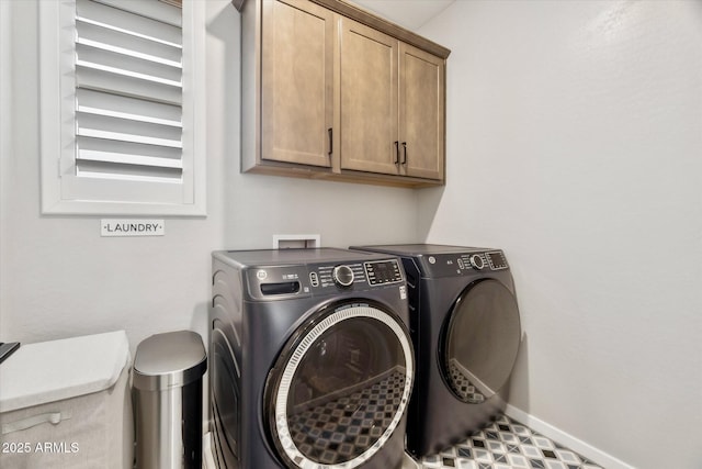 washroom featuring cabinets and washer and dryer