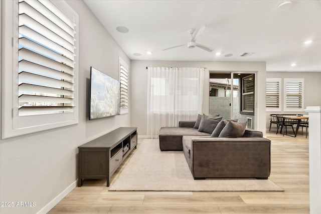 living room featuring ceiling fan, a healthy amount of sunlight, and light hardwood / wood-style floors