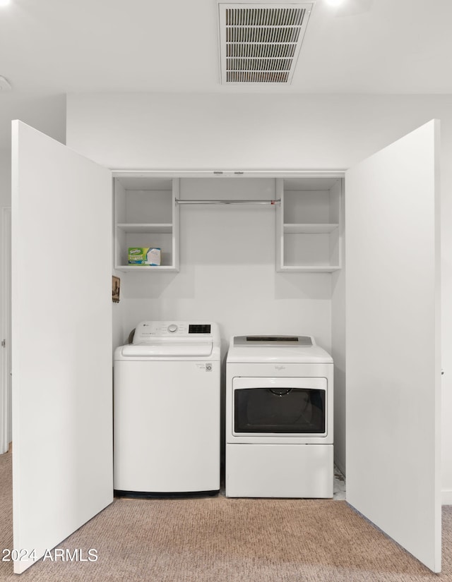 clothes washing area with washing machine and dryer and light colored carpet