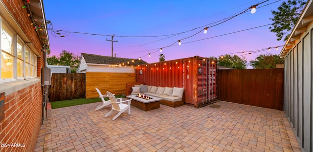 patio terrace at dusk with an outdoor living space with a fire pit