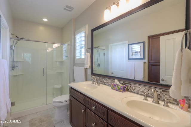 bathroom with a shower with shower door, vanity, tile patterned flooring, toilet, and decorative backsplash